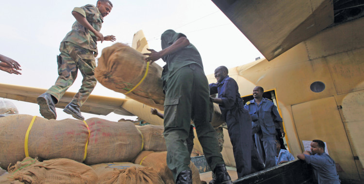 Army officers and workers in Khartoum, Sudan, unload relief aid from an Egyptian military plane for victims of floods and heavy rain in August 2013.