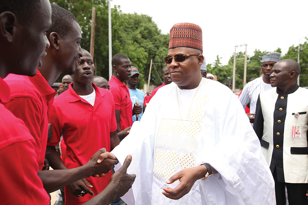 Borno State governor, Kashim Shettima, shakes hands with members of the Civilian Joint Task Force during an event in Maiduguri, Nigeria. [THE ASSOCIATED PRESS]