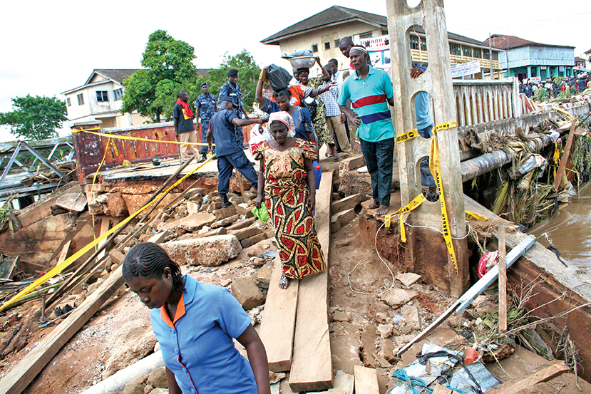 Des victimes marchent le long de bâtiments détruits suite à des inondations à Accra, au Ghana, en 2010. Les armées africaines cherchent de nouvelles façons de faire face aux menaces « affectant directement la population » telles que les inondations et les conflits à propos des droits fonciers. [VICKY MCNAUGHT-DAVIS]