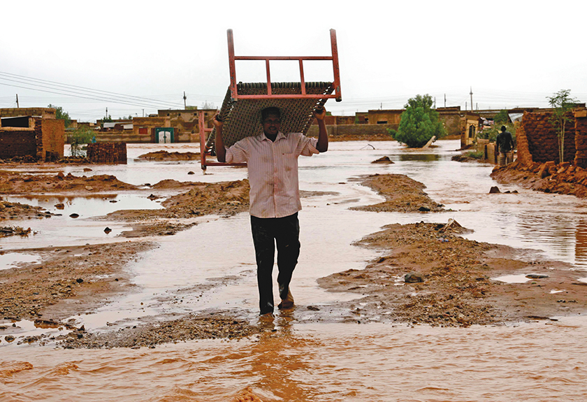 Un homme récupère des meubles d’une habitation endommagée par les inondations à Khartoum, au Soudan, en juillet 2014. La transformation du secteur de la sécurité dans un sens axé sur la population invite les armées à jouer un rôle actif dans la préparation et la réponse aux catastrophes. [ REUTERS ]