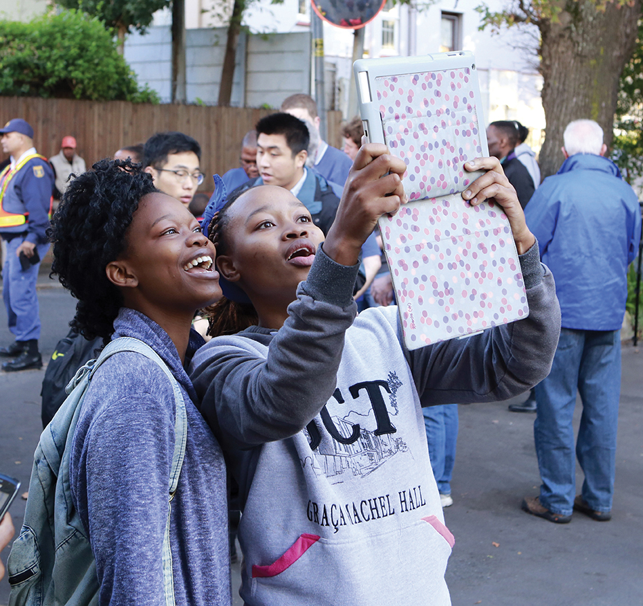 Two young voters take a photograph of themselves outside a polling station in Cape Town on May 7, 2014.  AFP/GETTY IMAGES