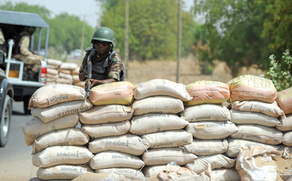 A Joint Military Task Force (JTF) soldier positions his rifle on sand bags on the road in northeastern Nigerian town of Maiduguri, Borno State , on April 30, 2013. Fierce fighting between Nigerian troops and suspected Islamist insurgents, Boko Haram at Baga town in the restive northeastern Nigeria, on April 30, 2013 left dozens of people dead and scores of civilians injured. But the military denied the casualty figures claiming it was exaggerated to smear its image. Meanwhile normalcy has return to the town as residents are going about their normal business.  AFP PHOTO/PIUS UTOMI EKPEI        (Photo credit should read PIUS UTOMI EKPEI/AFP/Getty Images)