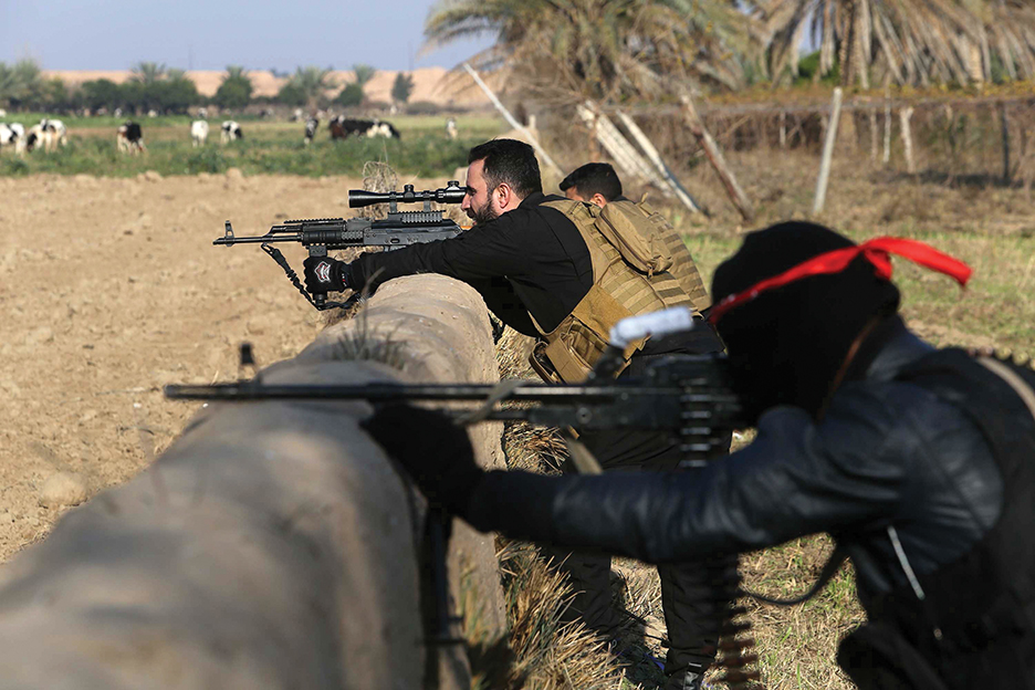 Pro-Iraqi government fighters, some belonging to the Iraqi Imam Ali Brigade, take part in an operation to secure an area they seized from the Islamic State (IS) militants in Yathreb near Balad, about 75 kilometres (45 miles) north of Baghdad on December 29, 2014. Iraqi forces backed by Sunni tribes advanced on December 28 into the town of Dhuluiyah, strategically located on roads linking the eastern province of Diyala to Salaheddin province, north of Baghdad in a new attempt to push out Islamic State group jihadists, officials said.   AFP PHOTO / MOHAMMED SAWAF        (Photo credit should read MOHAMMED SAWAF/AFP/Getty Images)