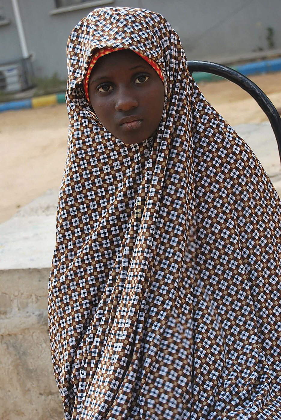 In this photo taken Wednesday, Dec. 24, 2014. Zahra'u Babangida, a 13 year-old girl arrested with explosives strapped to her body in Kano on Dec. 10, 2014. following a double suicide bombing, seen at the police headquarters in Kano, Nigeria. A 13-year-old says her father gave her to Boko Haram extremists and that she was arrested after refusing to explode a suicide bomb in Kano, Nigeria's second largest city in the north.  (AP Photo)