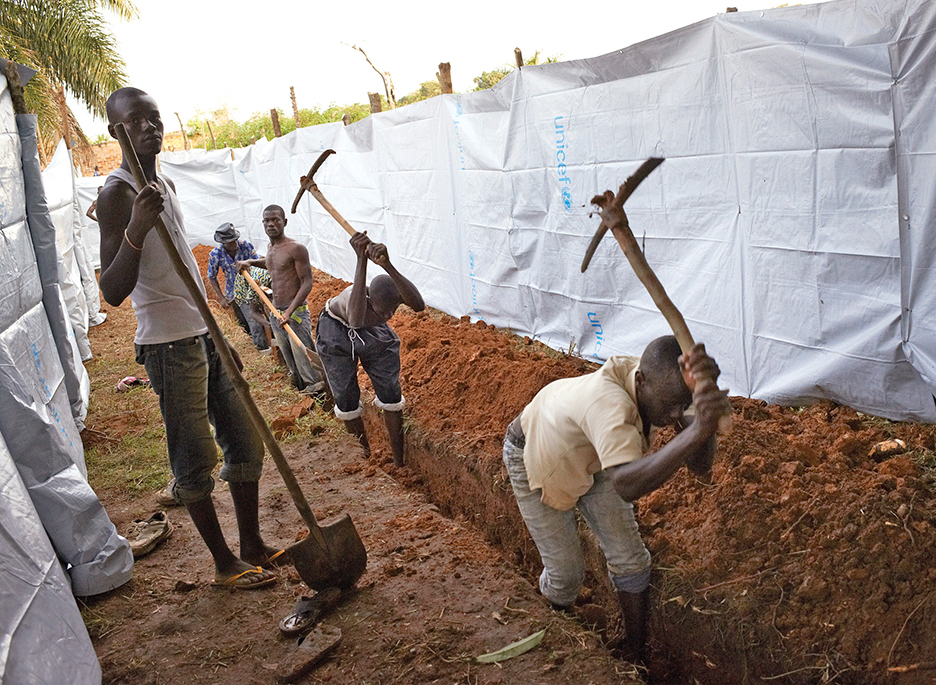 People dig a trench to be use as latrines for displaced residents camping at the Catholic church in Bangui, Central African Republic, December 10, 2013. France's president flew into Central African Republic hours after two French soldiers were killed in fighting and praised his troops for tackling "horrendous violence" against women and children and helping avert a slide into civil war. Pictures taken December 10, 2013. REUTERS/Sam Phelps (CENTRAL AFRICAN REPUBLIC - Tags: CIVIL UNREST MILITARY POLITICS RELIGION CONFLICT) - RTX16DUC