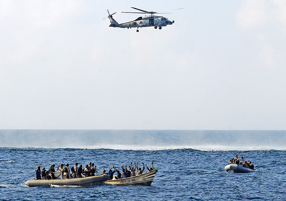 Visit, board, search and seizure (VBSS) team members from the guided-missile cruiser USS Vella Gulf (CG 72) close in on rigid-hulled inflatable boats to apprehend suspected pirates in Gulf of Aden in the Arabian Sea, February 12, 2009. A multinational naval force  seized nine suspected pirates in the Gulf of Aden on Thursday after receiving a distress call from an Indian merchant vessel, the U.S. Navy said.    REUTERS/Jason R. Zalasky/U.S. Navy photo/Handout   (GULF OF ADEN).  FOR EDITORIAL USE ONLY. NOT FOR SALE FOR MARKETING OR ADVERTISING CAMPAIGNS. - RTXBJZA