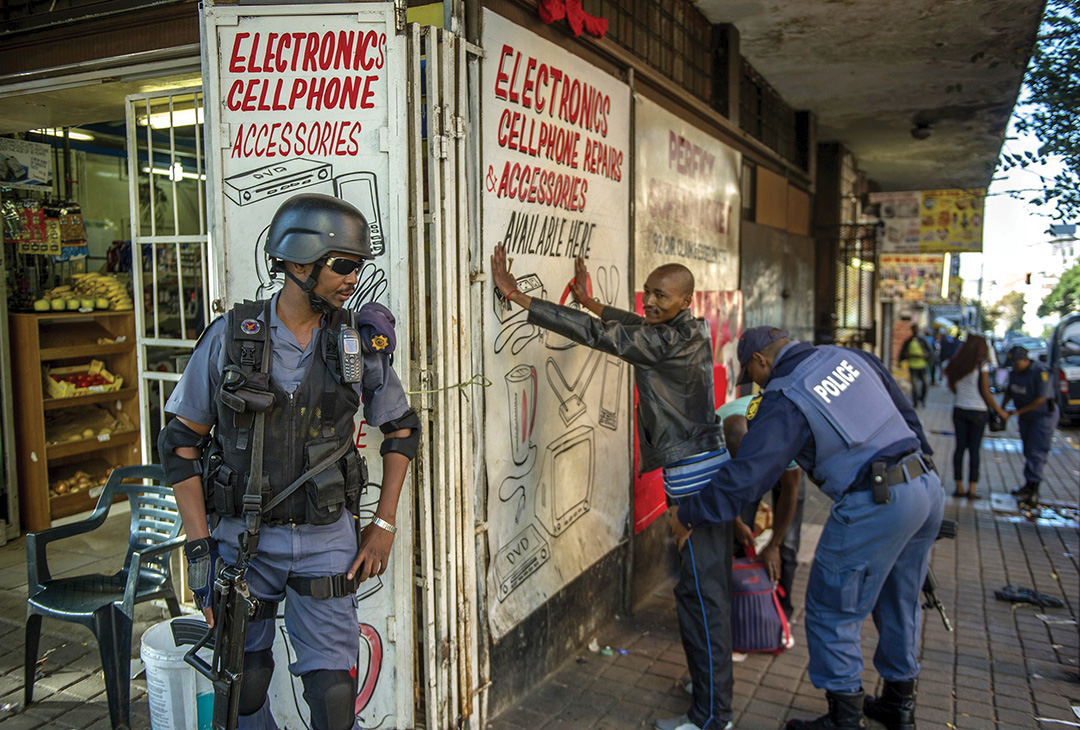 South African police officers conduct searches and identity checks in Johannesburg in 2015. AFP/GETTY IMAGES